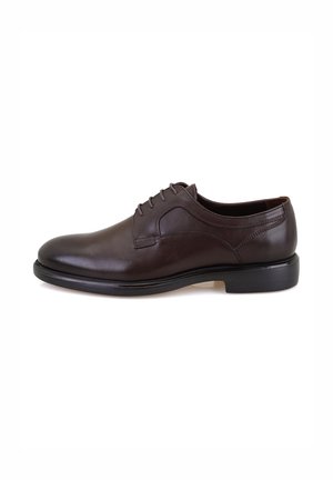 Chaussure habillée en cuir brun avec une texture lisse, un bout arrondi et six œillets. Présente une couture discrète et une semelle noire basse pour la stabilité.