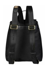 Zaino nero in nylon con spallacci in pelle. Presenta accessori dorati e dettagli del logo sugli spallacci regolabili. Design semplice e funzionale.