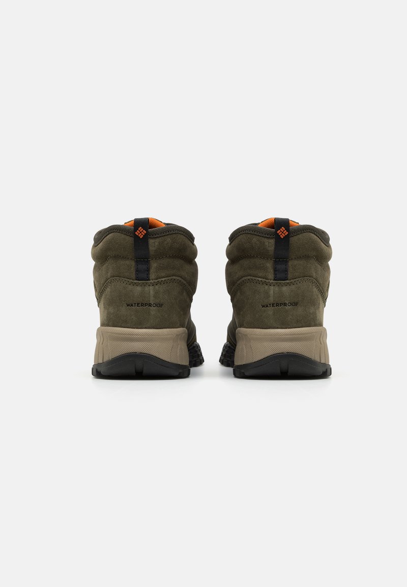 Waterdichte boots met een donker olijfgroen suede bovenwerk, contrasterende oranje accenten en een beige rubberen zool. Getextureerde achterkant en een stevige constructie.