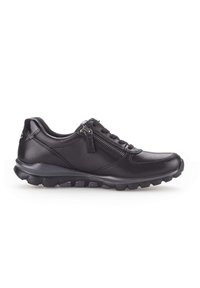 Chaussure décontractée en cuir noir avec fermeture éclair sur le côté, avant à lacets, col rembourré et semelle en caoutchouc texturé, présentée de profil sur fond blanc.