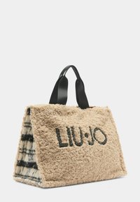 Borsa beige testurizzata con manici neri, dotata di logo ricamato. Esterno in morbido tessuto con motivo a quadri all'interno.