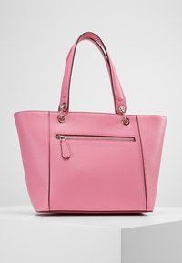 Sac tote en simili cuir rose avec deux poignées, une poche zippée à l'avant et une finition texturée. Forme rectangulaire avec une base structurée.