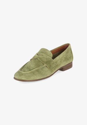 Groene suède loafer met lage bruine hak en decoratieve band over de wreef, schuin naar rechts op een witte achtergrond.