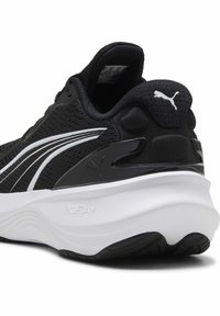 Schwarzer Sportschuh mit einem atmungsaktiven Mesh-Obermaterial, weißen Akzenten und einer gepolsterten weißen Mittelsohle mit strukturierten Details.