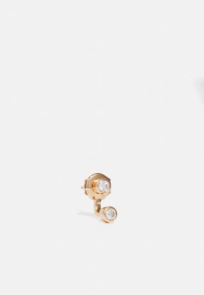 Guld-tone ørering med to runde klare sten, der viser et buet design. Den øverste sten er større end den nederste, begge sat i cirkulære indfatninger.