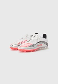 Scarpe da calcio bianche e argento con accenti rosa, caratterizzate da un design elegante, una parte superiore testurizzata e il marchio "Messi" ben in evidenza sul lato.
