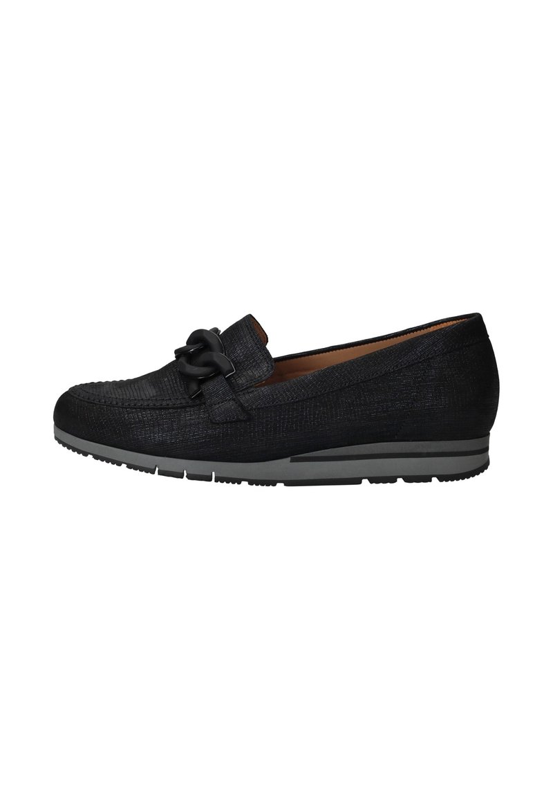 Zwarte loafers van een gestructureerde stof, met een opvallende decoratieve ketting en een contrasterende grijze rubberen zool voor extra grip en stabiliteit.