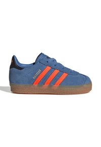 Blå semsket sneakers med gummisåle, med tre kraftige oransje striper og et svart akseent på hælen. Gull merke tekst på siden.