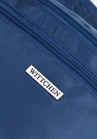 Modrá textilní peněženka s kovovou značkou stříbrné barvy s nápisem "WITTCHEN." Texturovaný povrch a kontrastní zipové detaily.