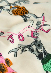 Hvidt stof med farverige tryk af stiliserede hjorte iført mønstrede outfits. Funktioner inkluderer pink bogstaver og forskellige blomsterdesigns.