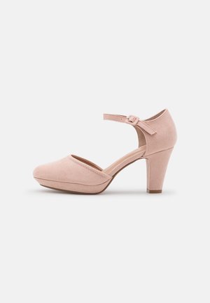 Chaussure à talon haut en daim rose avec un bout arrondi, une bride de cheville et un design de talon plus épais. Texture lisse avec des accents minimalistes.