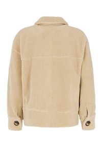 Beige fleecejakke med en tekstureret overflade, krave og knapmanchetter. Har en løs pasform og lige kant, med synlige syninger.