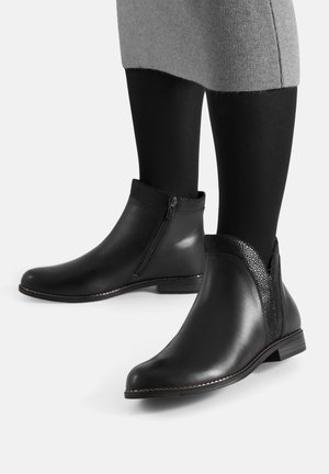 Czarne skórzane botki za kostkę z bocznym zamkiem, teksturowanymi akcentami i niskim obcasem. Gładka powierzchnia z kontrastującymi przeszyciami.