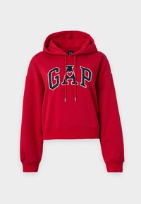 Czerwona krótka bluza z kapturem wykonana z miękkiego materiału. Posiada kieszeń kangurka, kaptur ze sznurkiem oraz granatowe logo „GAP” z serduszkowym akcentem.