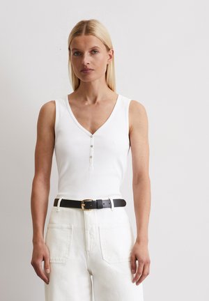 White ribbed tank top with a V-neckline and three buttons, paired with high-waisted white pants and a black belt with a gold buckle.