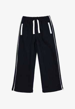 Mustat collegehousut, joissa on valkoiset sivupinnat, joustava vyötärö ja kaksi etutaskua. Valmistettu pehmeästä, tekstuurisesta kankaasta.