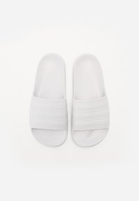 White slide sandals with three textured bands across the top, made of smooth material, featuring an open-toe design.