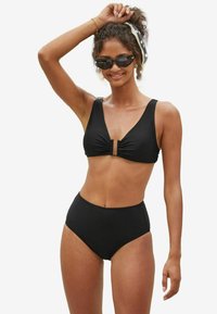 Fekete bikini szett, amely rücskös felsőrésszel rendelkezik, elöl záródik, széles pántokkal és magas derekú alsó résszel, mindez sima, rugalmas anyagból készült.