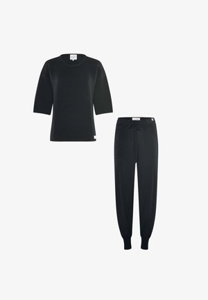 Schwarzes, geripptes Kurzarm-Top kombiniert mit schwarzen Jogginghosen mit Kordelzug und elastischen Bündchen, dargestellt auf weißem Hintergrund.