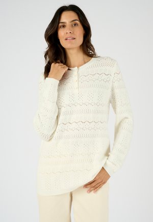 Gebreid pullover in off-white met een textuurpatroon, ronde halslijn en een placket met drie knopen. Lange mouwen en een ontspannen pasvorm.