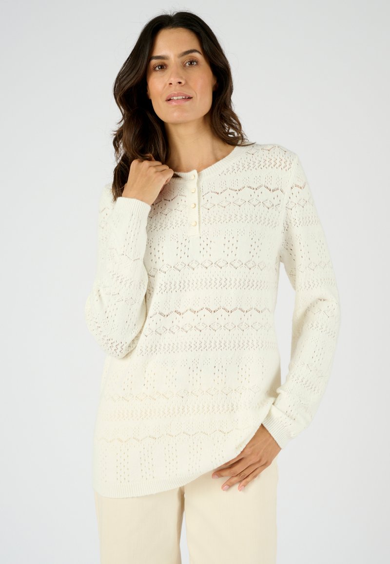 Pull en maille écru avec un motif texturé, col rond et patte de boutonnage à trois boutons. Manches longues et coupe décontractée.