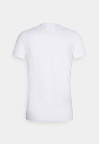 Vit kortärmad t-shirt i bomull. Har en enkel design med rund halsringning och en liten tygetikett på baksidan.