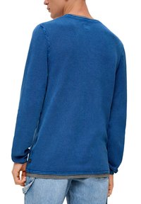 Langarm-Blau-Strickshirt mit strukturiertem Wabenmuster, rundem Ausschnitt, leichten Seitenschlitzen und Markenetikett am Saum.