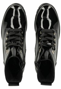 Bottines en cuir verni noir avec œillets dorés, lacets noirs, surface texturée et fermetures éclair sur le côté pour plus de facilité. Design à semelle plate.