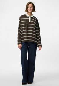 Bruin gestreepte longsleeve polo met een lichtgroene kraag, gecombineerd met donkere wijde jeans. Zachte stoftextuur, ontspannen pasvorm.