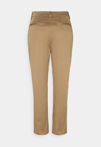 Pantalons beige ajustés avec une texture lisse, coupe droite et poches arrière avec des accents subtils.