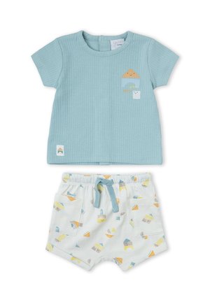 Camiseta de bebé azul claro acanalada con estampado de casa y nube, combinada con pantalones cortos blancos con patrones de casas coloridos y bolsillos delanteros.