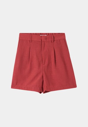 Pantaloni shorts rossi su misura in tessuto testurizzato, con pieghe davanti e una fascia larga in vita. L'orlo arriva sopra il ginocchio.