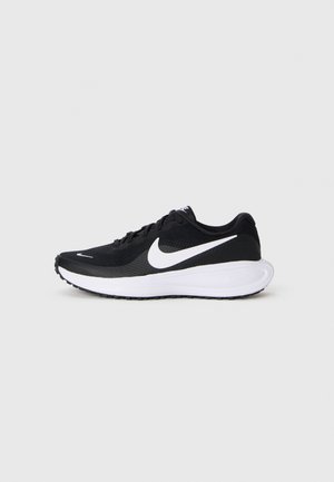 Sort løbesko med hvid swoosh-logo og tyk hvid sål, vist fra siden på en ensfarvet lysegrå baggrund.