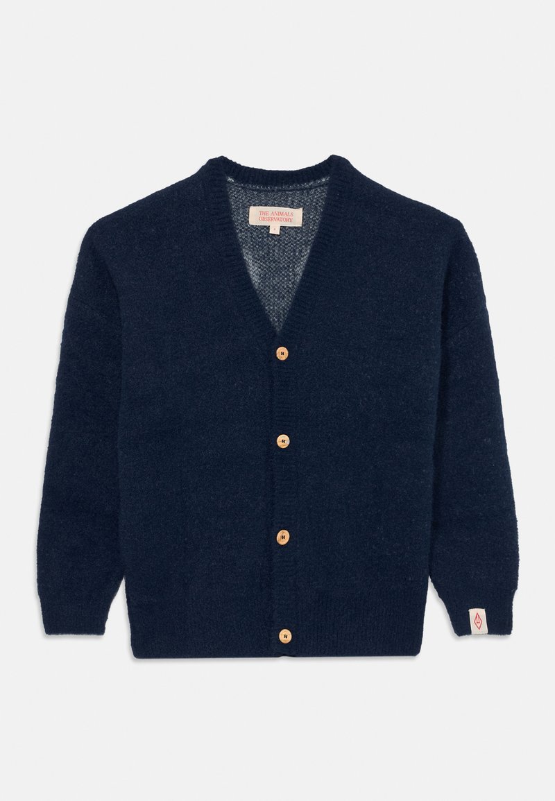 Marinblå cardigan gjord av mjukt tyg, med V-hals, träknappar och en logotyp på ärmen. Texturerad yta med långa ärmar.