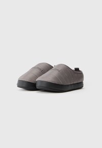Szürke slip-on cipők steppelt felsőrésszel, lekerekített orral és fekete gumitalppal. A hátsó részen található kis húzófül megkönnyíti a felhúzást.