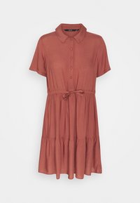 Robe chemise couleur rouille avec col, manches courtes et taille élastique. Présente une jupe à volants et une ceinture en tissu.