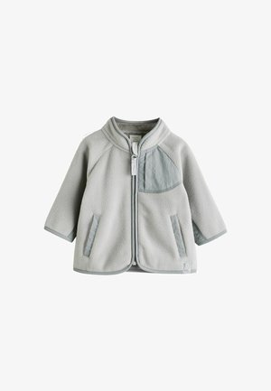 Gaišas pelēks flīsa džemperis ar mīkstu tekstūru, ar rāvējslēdzēju, divām priekšējām kabatām un kontrastējoša auduma paneļa kreisajā krūtī.