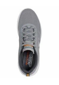 Zapatilla deportiva gris con parte superior de malla transpirable, puntera redondeada, suela bicolor y detalle del logo naranja en la lengüeta.