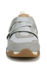 Scarpa sportiva grigia con materiali in camoscio e rete, dotata di ampie cinghie argentate e suola in gomma. Design minimalista, punta arrotondata.
