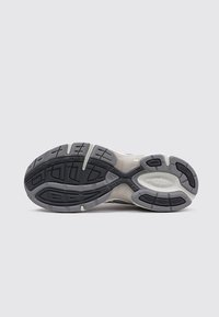 Semelle de basket avec un design gris clair et gris foncé, présentant un motif en caoutchouc texturé et des rainures ergonomiques pour l'adhérence et le soutien.