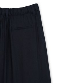 Marineblaue Leinenhose mit elastischem Bund, einer einzelnen Gesäßtasche und einer bequemen Passform mit einer glatten, texturierten Oberfläche.