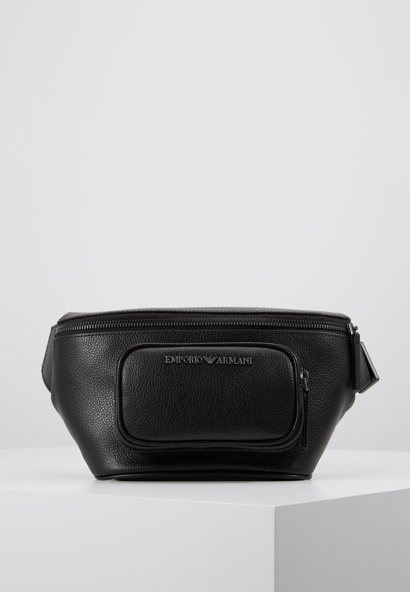 Černá kožená ledvinka s texturovaným povrchem. Obsahuje přední kapsu se zipem a stříbrný logový prvek. Zipové zapínání na vrchu.