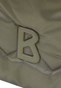 Olivnozeleno najlonska torba s kviltirano površino in izstopajočim dvignjenim logotipom "B" v usklajeni barvi. Ima vidne podrobnosti šivanja.