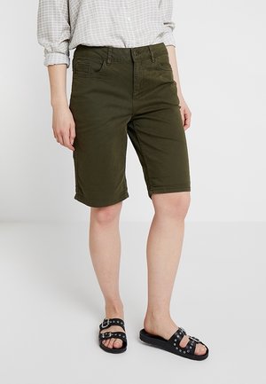 Bermudas en mélange de coton vert olive avec une fermeture à bouton à l'avant, des passants de ceinture, ainsi que des poches latérales et arrière, assorties à des sandales noires à enfiler.