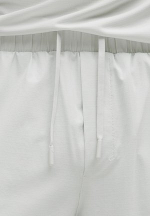 Pantaloni jogger gri deschis dintr-un material texturat, cu talie ajustabilă și șnururi, și un model subtil în carouri.