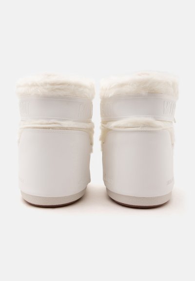 Paire de bottes d’hiver blanches avec doublure en fourrure, vues de dos sur un fond blanc uni.