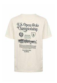 T-shirt beige en coton avec texte et graphismes noirs faisant la promotion du Championnat de Polo Open des États-Unis depuis 1904 à Palm Beaches, en Floride.