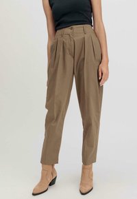 Khaki hoog-getailleerde broeken met voorplooien, twee zijzakken en een ritsluiting. Gladde katoenen stof, taps toelopende pasvorm en omgeslagen hems.