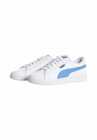 Zapatillas blancas con acentos en azul claro y el logo de PUMA. Parte superior de cuero suave, suela de goma plana y diseño de punta redonda. Cierre de cordones.