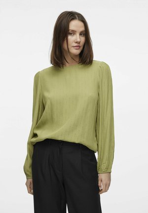 Olijfgroene blouse met lange mouwen, voorzien van een subtiele ribbels structuur, ronde hals en gathered manchetten, gecombineerd met zwarte broeken.